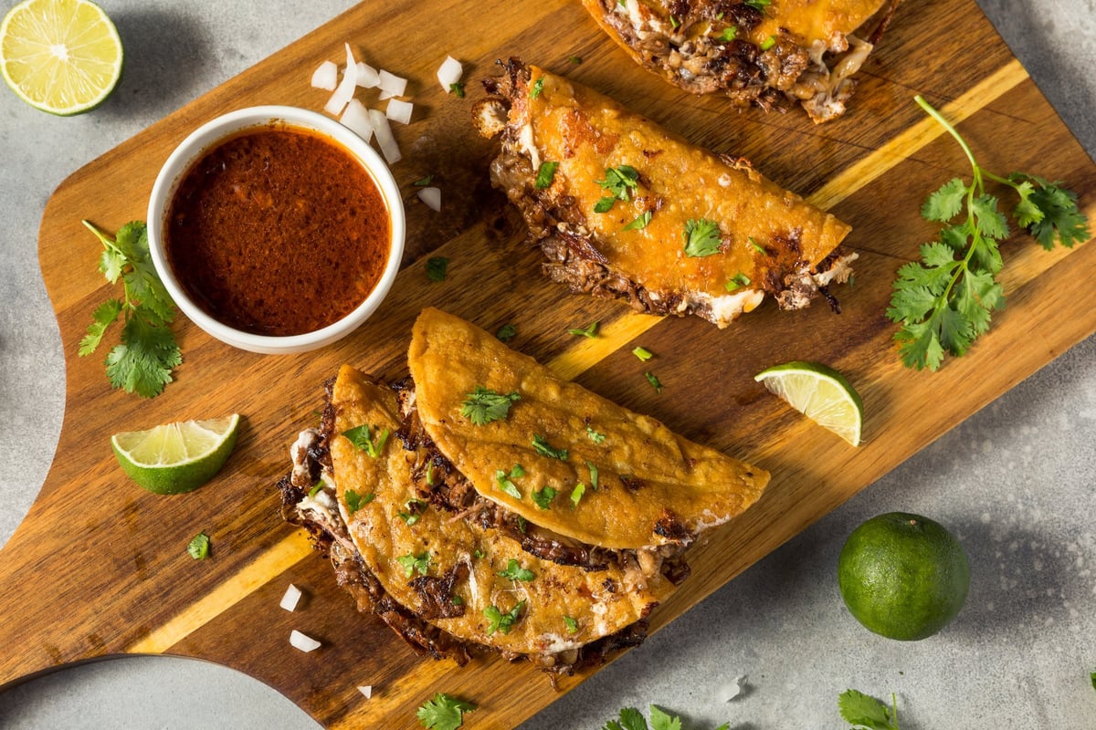 Steak birria tacos with melted cheese and sauce